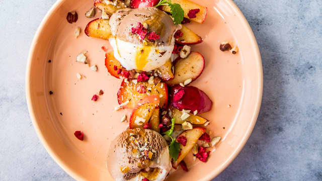 Dander eplene på et fat, og server med iskrem og hakkede hasselnøtter på toppen.