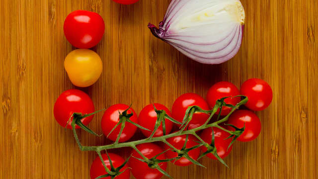 Finhakk rødløk, cherrytomater og basilikum. Bland det sammen og legg oppå det ristede brødet.