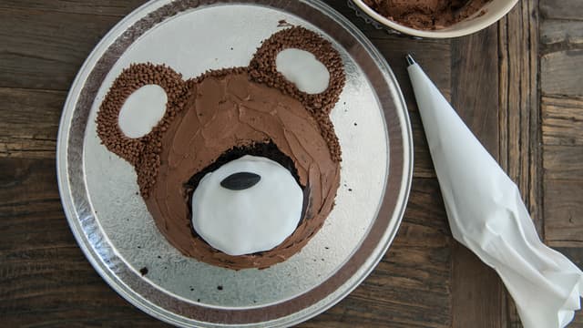 Bruk en lakrisbåt til snute og lag øyne av sorte nonstop. Bruk en kniv og skjær forsiktig munn i fondanten. Voilà! Verdens søteste bamsekake.