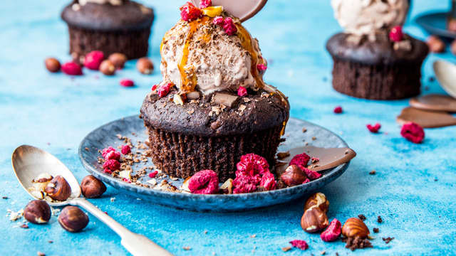 **Iskrem og pynt:** Avkjøl muffinsene helt og grav deretter ut litt av toppen på muffinsen med en skje. Plasser iskulen oppi muffinsen og pynt med et lekkert sjokoladehjerte og frysetørrede bringebær.