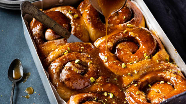 Ha resten av karamellsausen og de hakkede pistasjnøttene over de nybakte bollene med en gang de tas ut av ovnen.