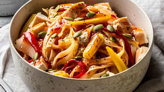 Stek grønnsakene raskt i olje til det får farge. Ha i kyllingstrimlene, de kokte nudlene og sweet chilisaus. Bland alt godt sammen og server.