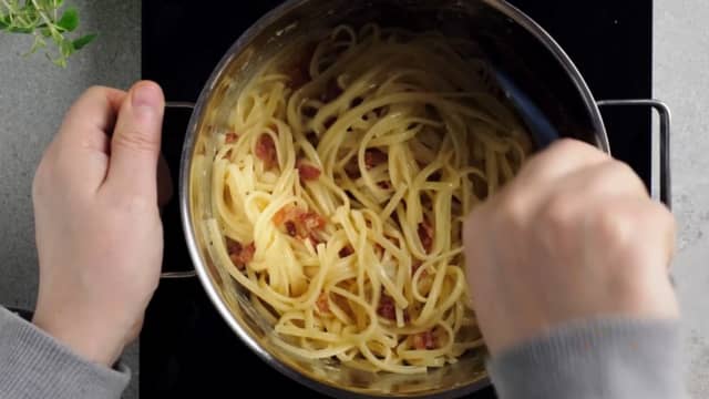 Vend eggeblandingen inn i pastaen. Spe med kokevannet til sausen får en kremet, silkemyk konsistens. Pass på at kjelen eller stekepannen ikke er for varm, da kan eggeblandingen bli til en kornete eggerøre.