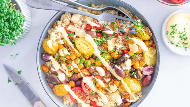 Anrett quinoaen i en bolle og topp med stekte poteter, paprika, sopp, kikerter, cherrytomater og oliven. Topp salaten med dressingen og vend alt sammen før servering.