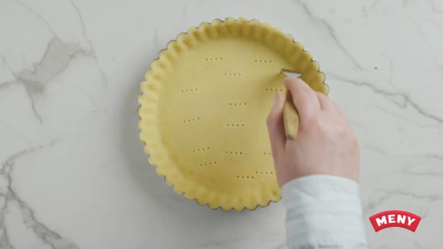 Rull ut paideigen i en form på ca. 24 cm. Lag prikker i paibunnen med en gaffel.