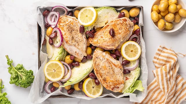 Legg perlepoteter, sitronskiver, kål, løk og oliven i en ildfast form. Vend inn olivenolje og krydre med salt og pepper. Legg kyllingbrystene oppå grønnsakene.