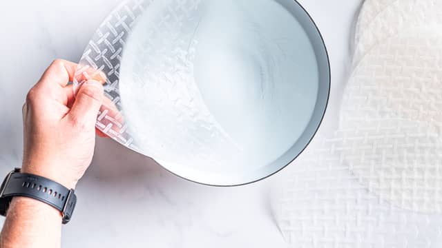 Dypp en rispannekake i en bolle med kaldt vann i 2 sekunder. Pass på at hele rispannekaken er under vann.