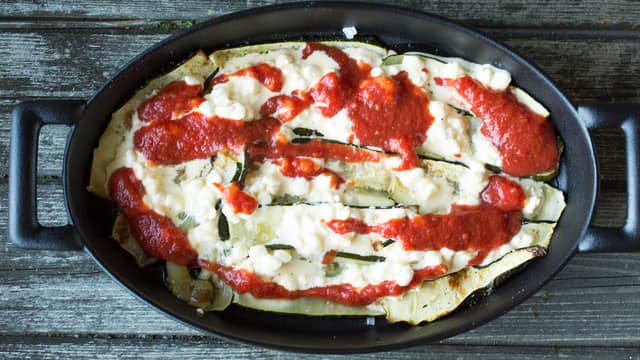 Fordel et par spiseskjeer cottage cheese-blanding og tomatsaus over skivene og topp med en pastaplate.