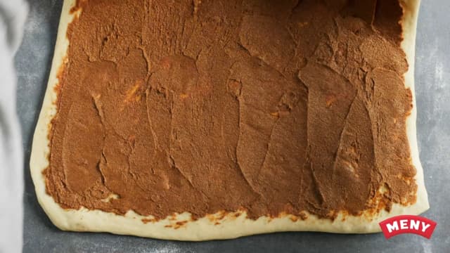 Smør kanelfyllet utover hele flaten, og topp fyllet med de stekte eplebitene