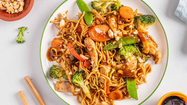 Ha nudlene i woken sammen med kyllingen, grønnsakene og til slutt woksausen. Smak til med salt og pepper.