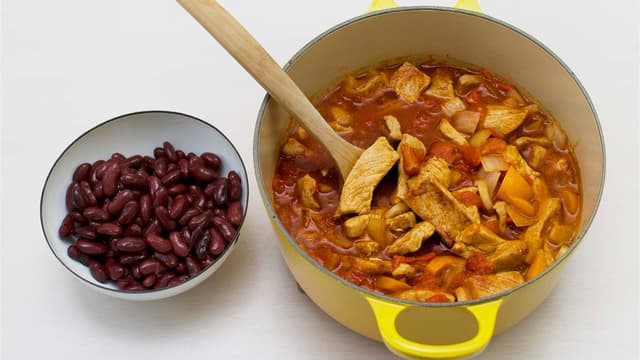 Tilsett krydder, hakkede tomater og kraft. Kok opp og la koke i ca. 20 min. Ha i avrente bønner, varm opp og smak til med salt og pepper.