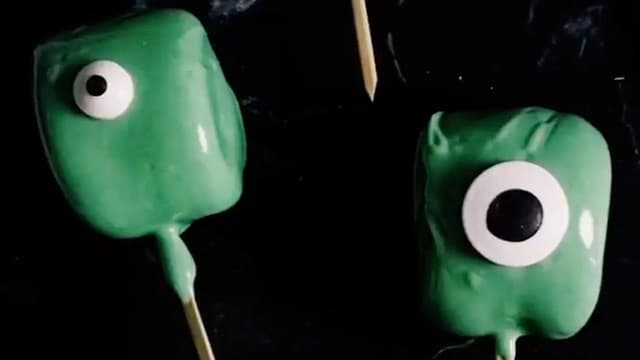 Stikk en marshmallows på grillpinne og dypp den i sjokoladen til hele er dekket. Sett på et spiselig øye og sett sjokoladen i kjøleskapet så den stivner. Om du ikke får kjøpt spiselige øyne, kan du lage det med melisglasur og lakris.