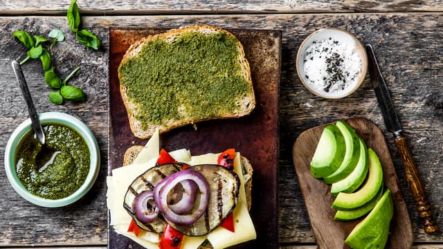 Legg grillede grønnsaker, avokado og ost på den ene skiven og topp med den andre, pesto-sidene mot hverandre.