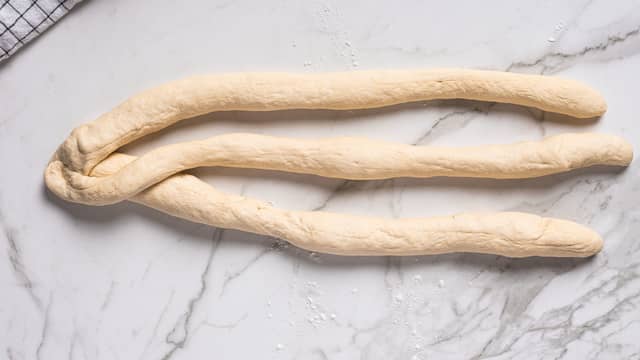 Legg venstre pølse over den i midten, legg så høyre pølse over den som nå ligger i midten.