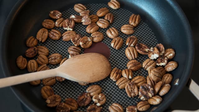 Rist nøttene i en varm, tørr panne. Legg dem over på en tallerken.