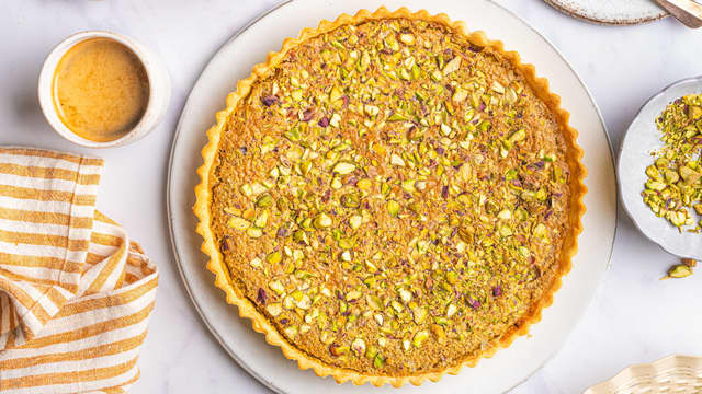 Stek terten midt i ovnen på **180 grader i ca. 30 minutter** til den begynner å heve litt langs kanten og kjennes fast ut i midten. Avkjøl terten litt før servering.