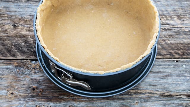 Kjevle deigen ut og kle en 24 cm. springform med den. Pass på at deigen går høyt nok opp på kantene. Den vil krympe litt under steking.