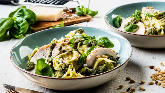 Skjær kyllingen i skiver, og ha over tortellini. Topp med pinjekjerner og høvlet parmesan.