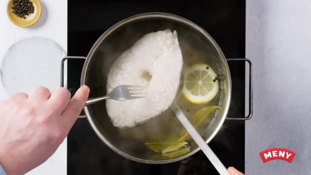 Skru ned varmen og la skreiskivene trekke i vannet i ca. 15 minutter til de skiver seg når du presser lett på dem. Løft fisken forsiktig ut av vannet med en hulløse.