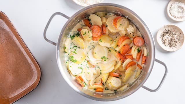 Bland inn grønnsaksskivene og la det hele småputre i 10–15 minutter. Rør forsiktig av og til, så det ikke fester seg i bunnen.