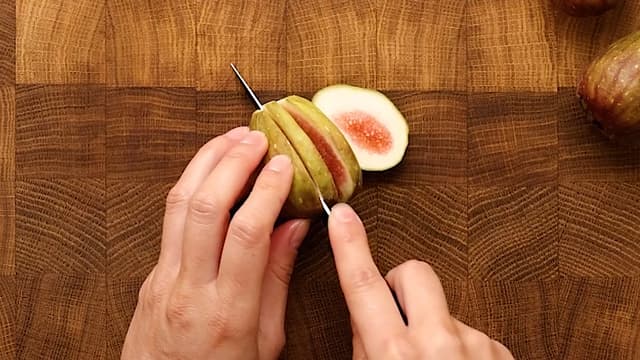 Kutt av stilkfestet på fiken og del dem i skiver. Del chevre i skiver.