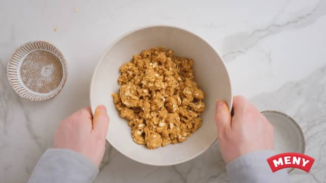 **Crumble:** Start med å lage crumble. Bruk hendene og smuldre sammen kaldt smør, hvetemel, brunt sukker og havregryn.