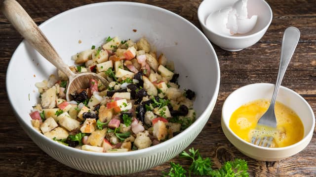 Ha brødsmuleblandingen over i en bolle. Bland dem godt med hakkete svisker, epleterninger, pisket egg, smeltet smør, allehånde, finhakket persille, timian, salt og pepper.