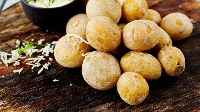 Server de saltkokte potetene med aioli blandet med bladpersille.