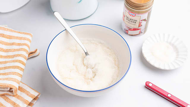 Mens sukkeret koker blander du sammen gelatinpulver og kaldt vann i en bolle.