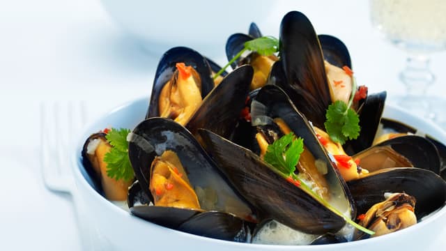 Hell kraften over blåskjellene og skvis til slutt over sitron og lime etter smak. Dryss over litt frisk koriander.