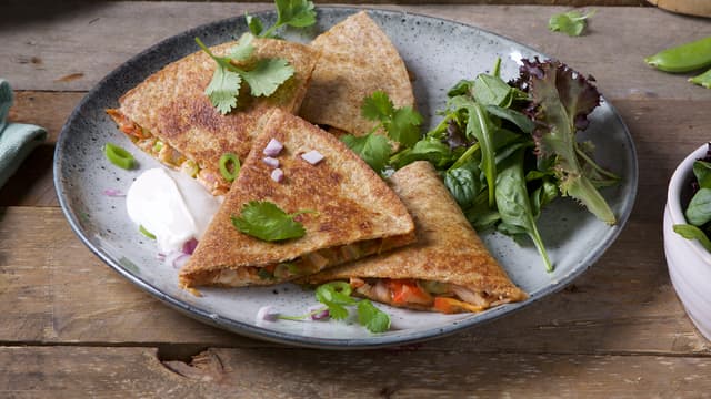 Server quesedillasene med rømme og frisk grønn salat.