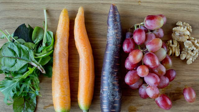 Skrell og del gulrøttene i jevne staver. Legg gulrøttene over i en liten langpanne sammen med druene. Drypp over 2 ss olivenolje og dryss over litt salt. Sett pannen i ovnen og bak i ca. 20 minutter, eller til gulrøttene blir gylne og knapt møre.
