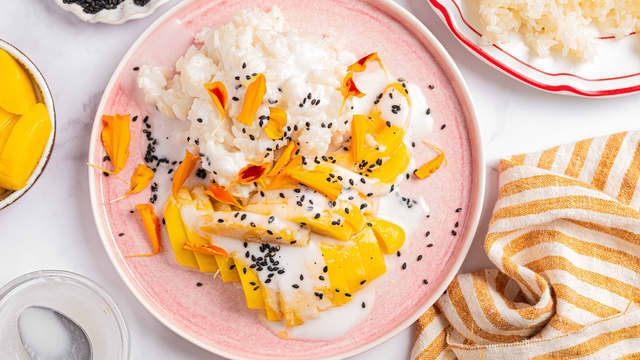 Anrett risen på tallerkener sammen med mangoskiver og strø over sesamfrø. Ha gjerne over litt ekstra kokossaus før servering.