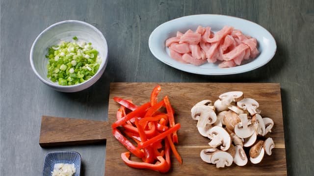 Skjær kalkunen i biter og sopp i skiver. Finhakk hvitløk og paprika og finsnitt vårløk.