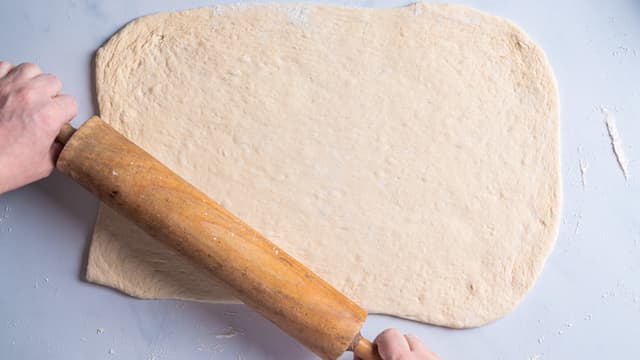 Del deigen i to og legg den ene deigen tilbake på benken med mel og kjevle den ut til en rektangel som er ca 30x60 cm.