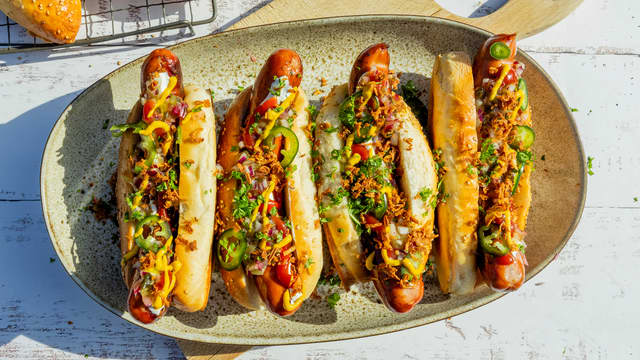 Pølser på grillen med relish og spicy topping i hjemmebakte pølsebrød