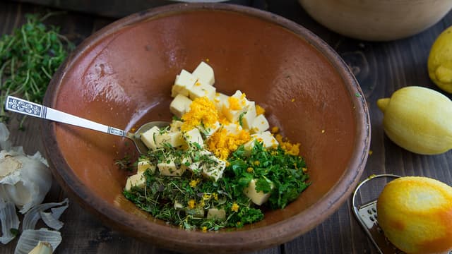 Bland romtemperert smør med med finrevet skall fra 1 appelsin, 1 sitron, finhakket persille, finhakket timian, hvitløk, salt og pepper.