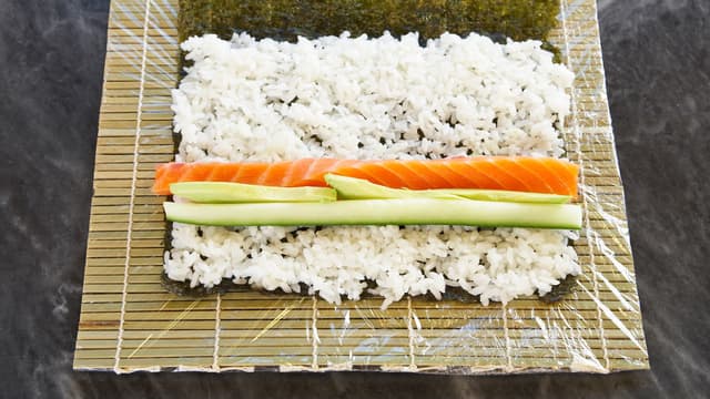 Legg strimler av laks i en stripe på risen sammen med mango, avokado eller agurk. Du kan ha alt i en makirull, eller lage flere forskjellige typer.