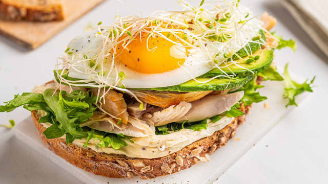Ha brødskivene på tallerkener og topp med kremost, salat, avokado, kylling og speilegg på toppen. Smak til med litt salt og pepper.