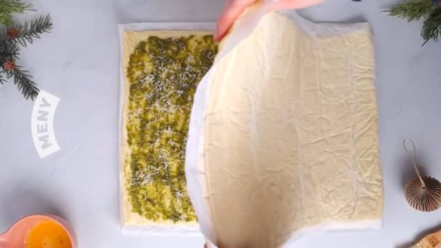 Ha revet ost over hele bunnen, legg den andre pizzabunnen over, kant i kant.