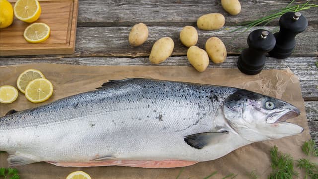**Rens laksen:** Skrap fisken fra halen og ned mot hodet med en kjøkkenkniv til den er helt fri for skjell. Skyll og vask laksen under kaldt rennende vann, og tørk den med kjøkkenpapir både inni og utenpå.