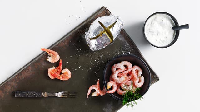 Server de bakte potetene med squash i dillkrem, hakket løk og reker.