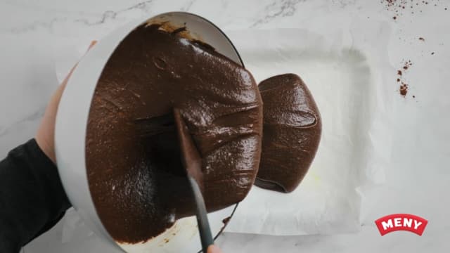 Hell røren i kakeformen, og ha nøttene på toppen av kaken. Dytt dem litt nedi kakerøren med en skje.