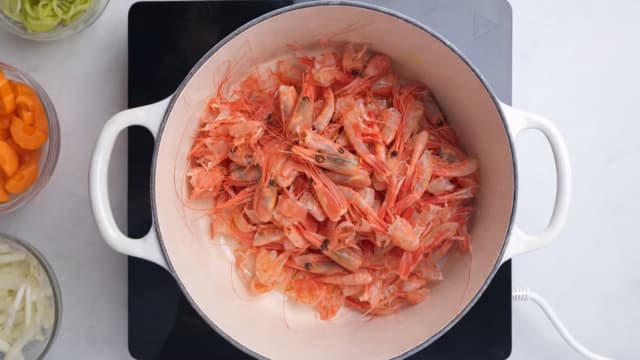 Ha skallene oppi gryta, og la det svette et par minutter.