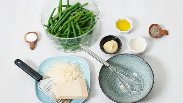 Riv parmesan. Finhakk hvitløk, bland dressingen og vend inn bønner og parmesan.