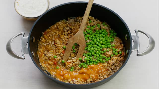 Tilsett kyllingkjøttdeig og stek til den skifter farge. Rør inn saus og erter. La småkoke i ca. 5 min.