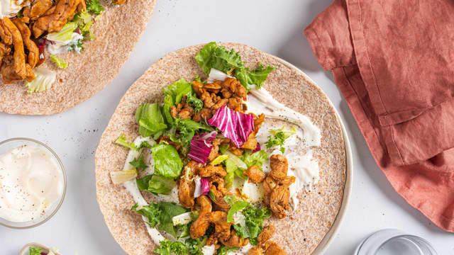 Anrett tortillalefser på to tallerkener og fyll med aioli, salat, og stekt kylling.