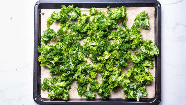 Gni inn grønnkålen med litt olivenolje og fordel grønnkålen utover et stekebrett med bakepapir, dryss over flaksalt etter smak.