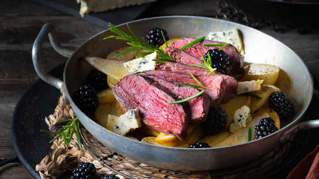 Anrett poteter og pærer på et fat. Skjær reinsdyrkjøttet i fingertykke skiver og legg over. Dander retten med friske bjørnebær og biter av Selbu Blå rett før servering.