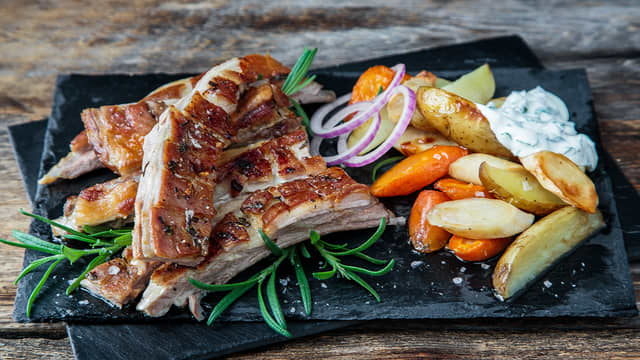 Del lammeribben i serveringsstykker ved å føre kniven nedover langs bena. Server med de møre rotgrønnsakene og urtedippen.